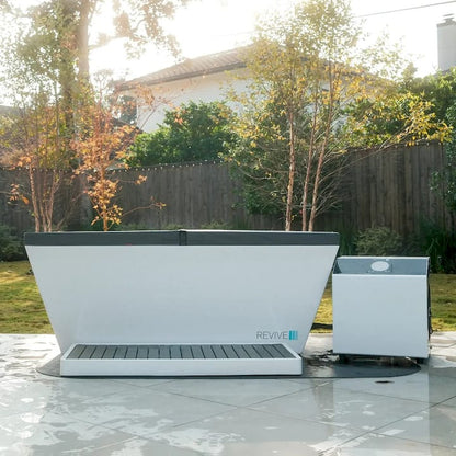 Outdoor setting with a large white and gray Cold tub  and a chiller on a tiled patio.