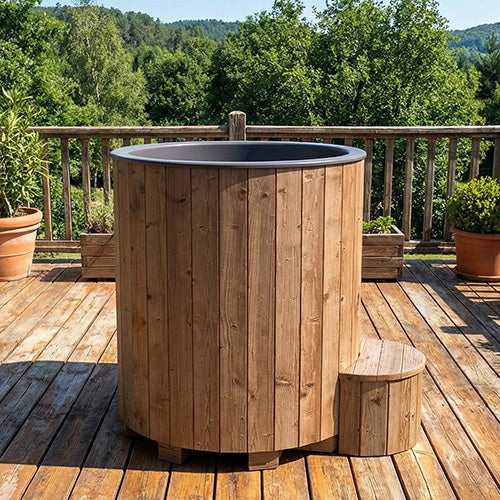 Wooden hot tub on a wooden deck with greenery in the background