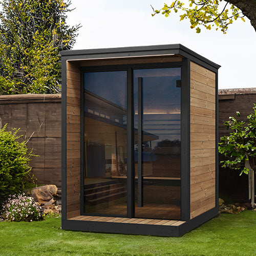 Modern garden sauna with wooden exterior and glass walls in a backyard setting.
