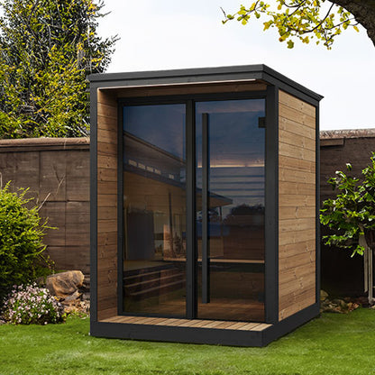 Modern garden sauna with wooden exterior and glass walls in a backyard setting.