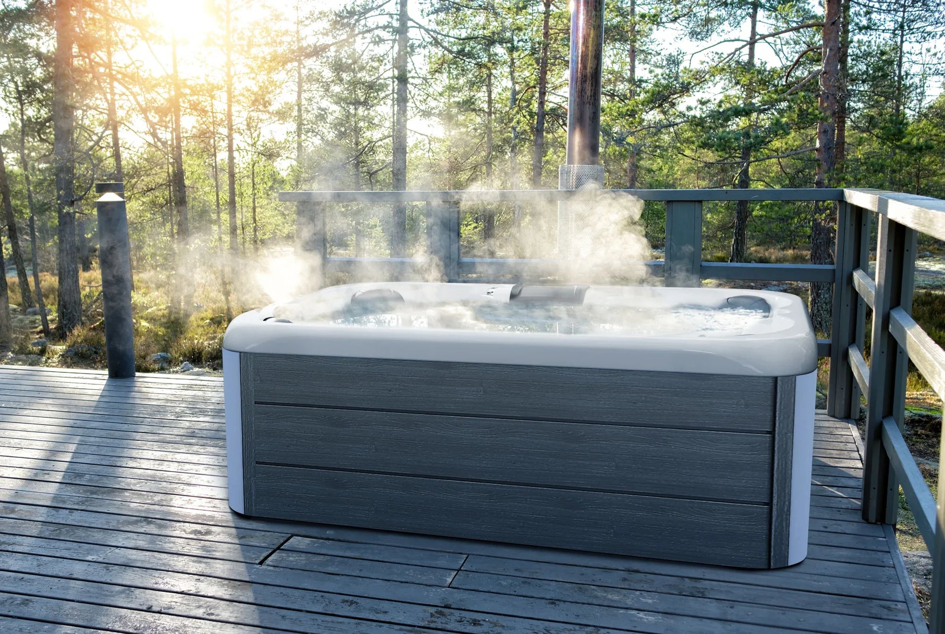 Hot tub on a wooden deck with mist rising, surrounded by trees