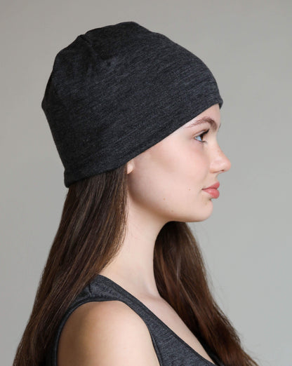 Woman wearing a grey beanie against a neutral background